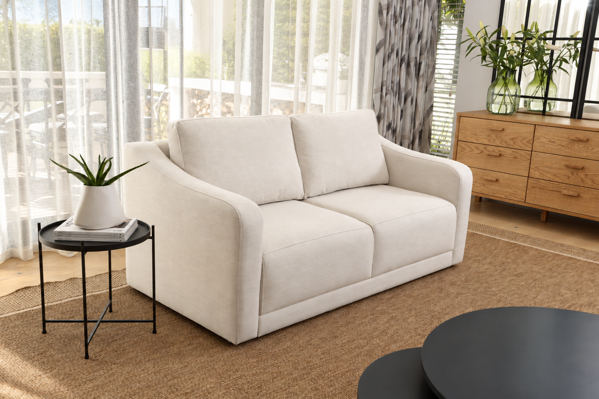 Ivory upholstered sofa beside an oak sideboard in a sunlit living room